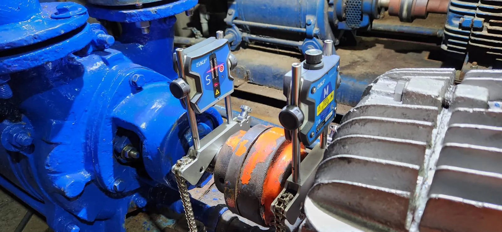 Conjunto de bomba y motor con acoplamiento naranja en una planta industrial