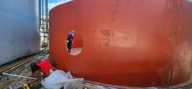 Operario realizando una apertura soldada en un tanque cilíndrico