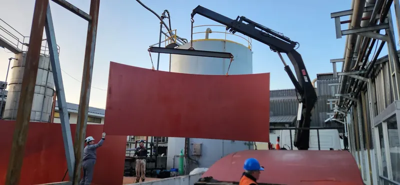 Grúa izando una estructura de acero en una planta industrial