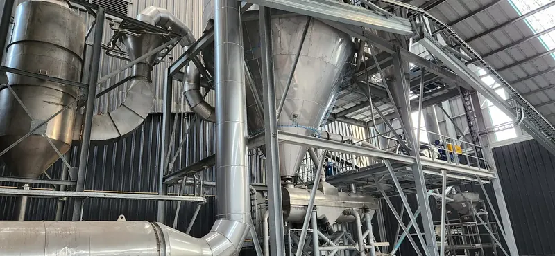 Interior de una torre de proceso con plataformas, escaleras y redes de cañerías